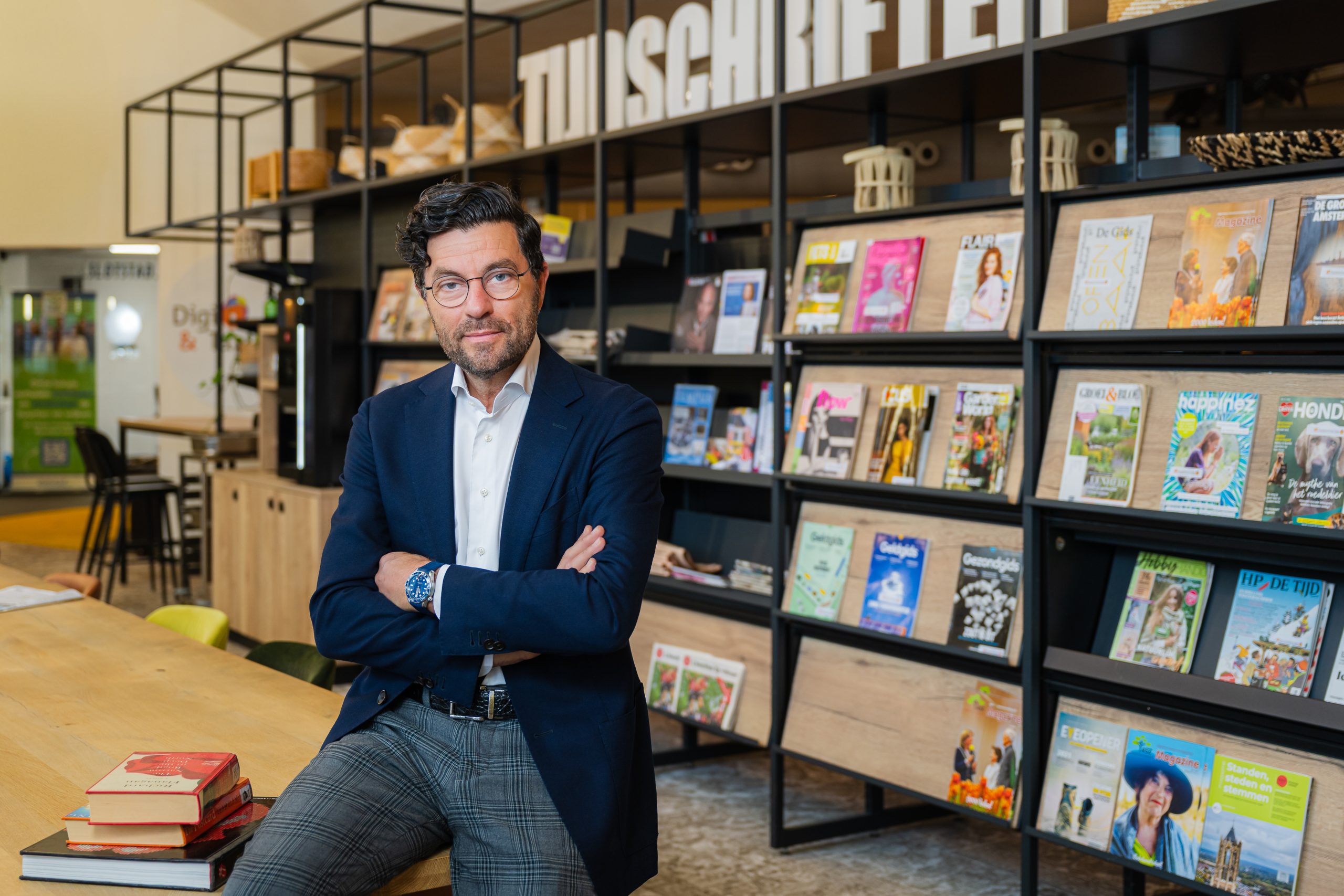 John Sijmonsbergen, directeur-bestuurder KunstenHuis Idea, in een bibliotheek tussen tijdschriften